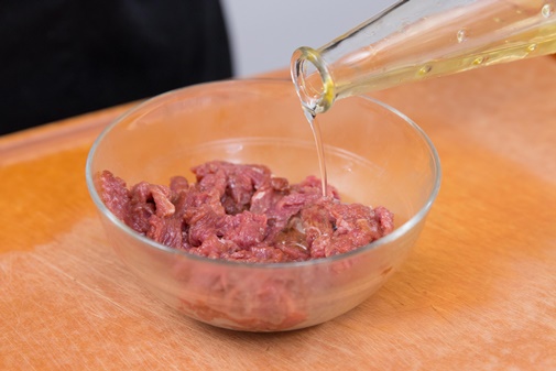 Cho thêm một chút dầu ăn vào công đoạn ướp cũng giúp thịt bò mềm, hạn chế bị dai hơn khi xào (Ảnh minh hoạ)